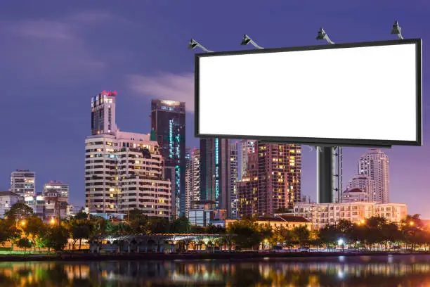 Billboard with blank and buildings in a big city by night