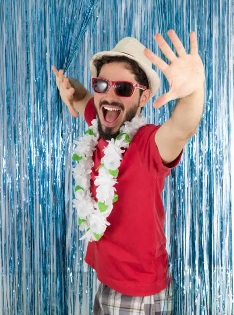 Photo of Young adult in a state of euphoria. Caucasian man in red clothes and sunglasses. Funny. Euphoria and joy. Carnival, New Year's Eve, mardi gras.