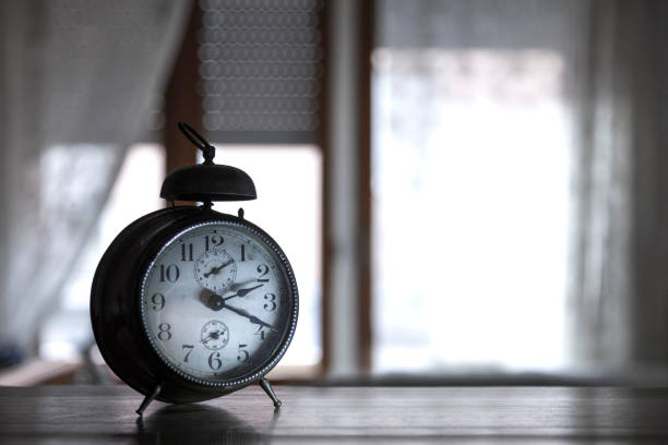 istock Vintage 's alarm clock put on wooden table on window background - Sleep time Concept 904631040