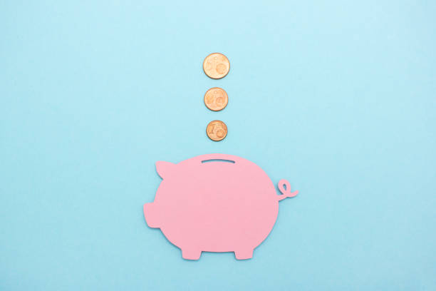 Cent coins flying into a paper cut piggy bank Start saving money early cent sign photos stock pictures, royalty-free photos & images