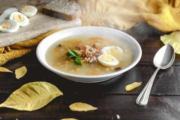 istock Healthy and warming winter soup with rice, chickpeas, chicken, ham and boiled egg over rustic wooden table background. Spanish soup (Puchero Andaluz). Winter food concept 904639020