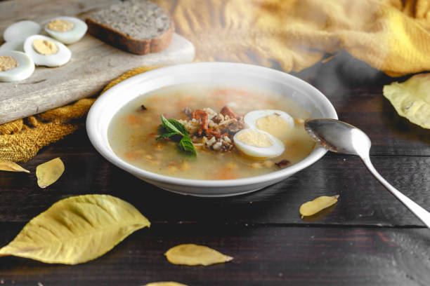 istock Healthy and warming winter soup with rice, chickpeas, chicken, ham and boiled egg over rustic wooden table background. Spanish soup (Puchero Andaluz). Winter food concept 904639022