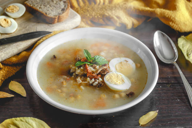 istock Healthy and warming winter soup with rice, chickpeas, chicken, ham and boiled egg over rustic wooden table background. Spanish soup (Puchero Andaluz). Winter food concept 904639026