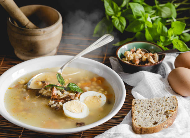 istock Healthy and warming winter soup with rice, chickpeas, chicken, ham and boiled egg over rustic wooden table background. Spanish soup (Puchero Andaluz). Winter food concept 904639028
