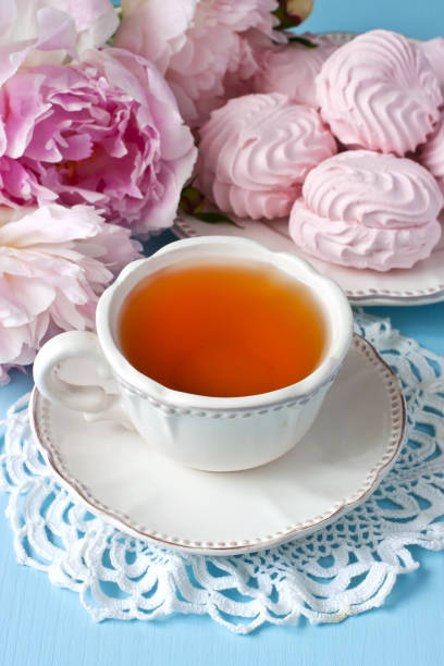 istock Still life with tea cup, zephyr cookies and peonies 904639340