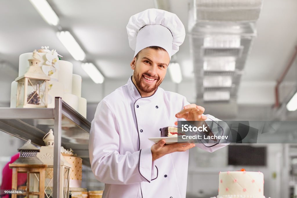 Mann-Konditor mit einem Kuchen in seine Hände in die pastr - Lizenzfrei Konditor Stock-Foto