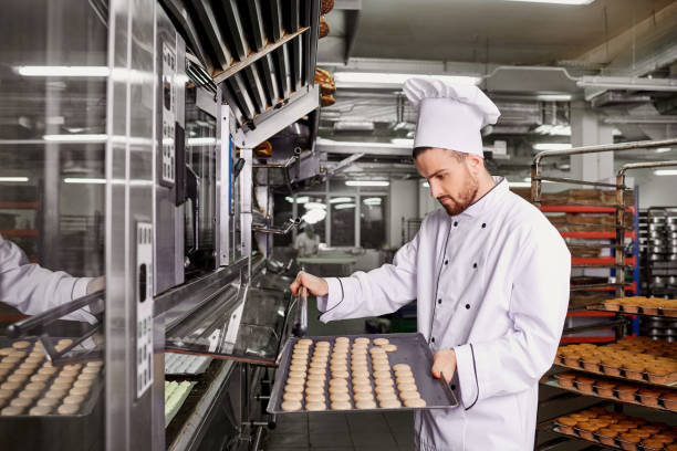 istock A man baker with a tray of cupcakes in a bakery 904643758