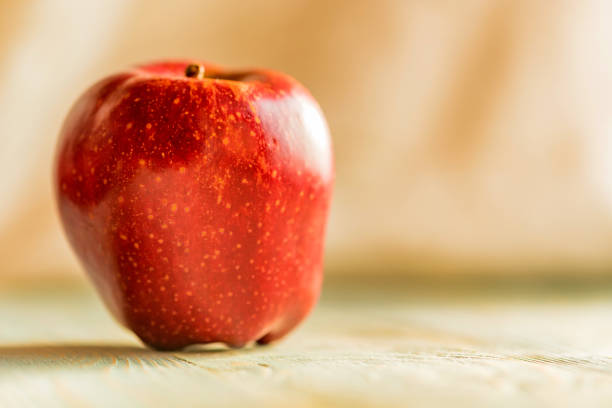 istock Red juice ripe apple on wooden background 904647330