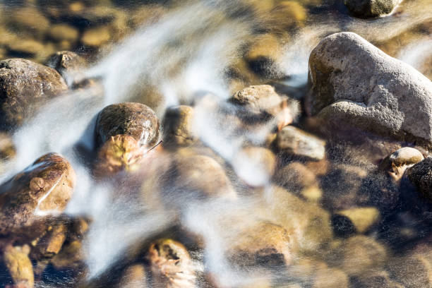 closeup de corriente de la roca superficial con corriente movimiento de larga exposición de agua chapoteando en otoño con piedras - autumn water leaf stream fotografías e imágenes de stock