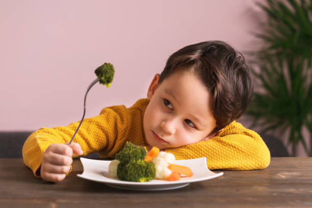 istock Child is very unhappy with having to eat vegetables. 904658668