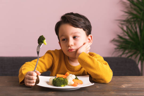 istock Child is very unhappy with having to eat vegetables. 904658916