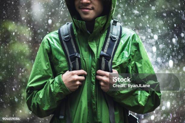 Young Man Hiking In Rain With Waterproof Jacket Stock Photo - Download Image Now - Raincoat, Outdoors, Rain