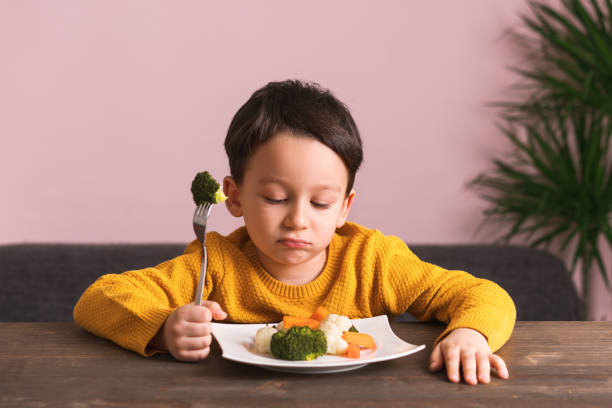 istock Child is very unhappy with having to eat vegetables. 904661266