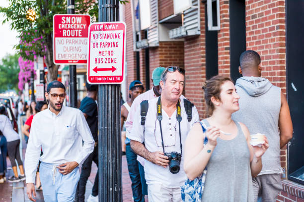 happy young people students walking in evening in downtown georgetown neighborhood and brick buildings, stores, eating ice cream - bus transportation georgetown washington dc washington dc imagens e fotografias de stock