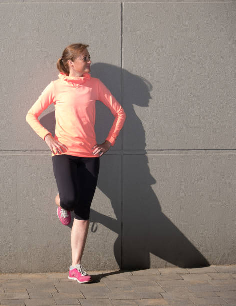 deportiva mujer posando contra una pared - foto de stock