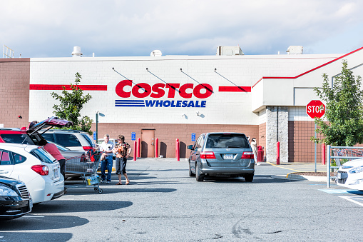 Fairfax: People with shopping carts filled with groceries goods, products walking out of Costco store in Virginia in parking car lot