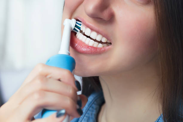 istock Close up of brushing teeth with electric toothbrush 904662814