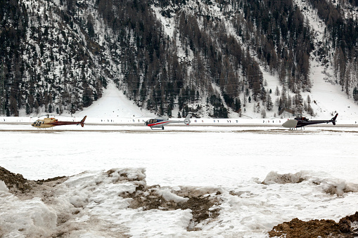 Three helicopters on a row in the airport of St Moritz Switzerland in the alps