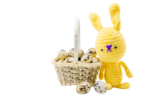 istock Quail eggs in a gray basket and yellow doll rabbit in crochet 904676556
