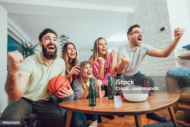 Group Of Friends Watching A Basketball Game On Tv Stock Photo - Download Image Now - Apartment, Hanging, Living Room