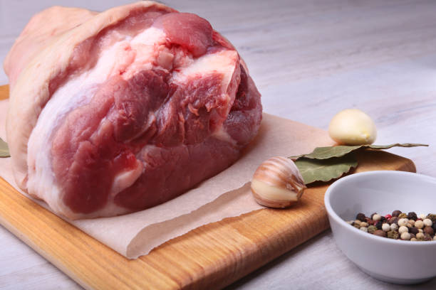istock Raw pork knuckle, Aromatic dried bay leaves, garlic and spices on a cutting board. Selective focus. Ready for cooking. 904676878