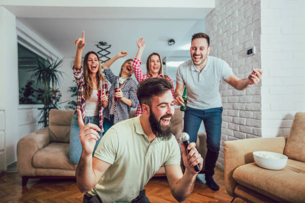 Group of friends playing karaoke at home Group of friends playing karaoke at home. Concept about friendship, home entertainment and people karaoke photos stock pictures, royalty-free photos & images