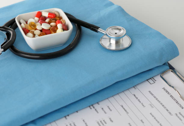 istock stethoscope a glass of water and pills on a uniform 904680202
