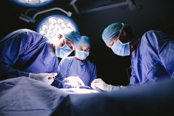 grupo de cirujanos haciendo cirugía en el hospital - performance surgery doctor men fotografías e imágenes de stock