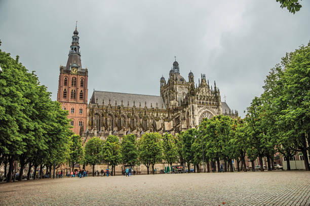 large place pavée et arbres en face de la cathédrale de st. john's dans une journée nuageuse à ' s-hertogenbosch. - gracious photos et images de collection