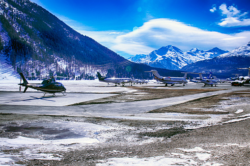Private jets, planes and helicopters in the beautiful snow covered mountains of alps in St Moritz Switzerland