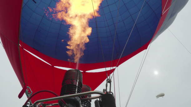 istock Hot air balloon. Burner directing flame into envelope on background helium blimp high in sky 904687606