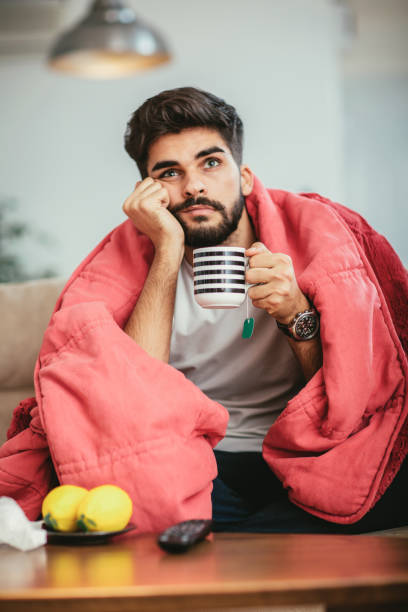 istock Young ill man drinking hot tea at home 904694228