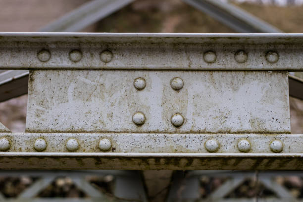 istock Steel construction, lattice connected by an old method for rivets. Truss in the old bridge connected by rivets on the river. Winter scenery. 904694366