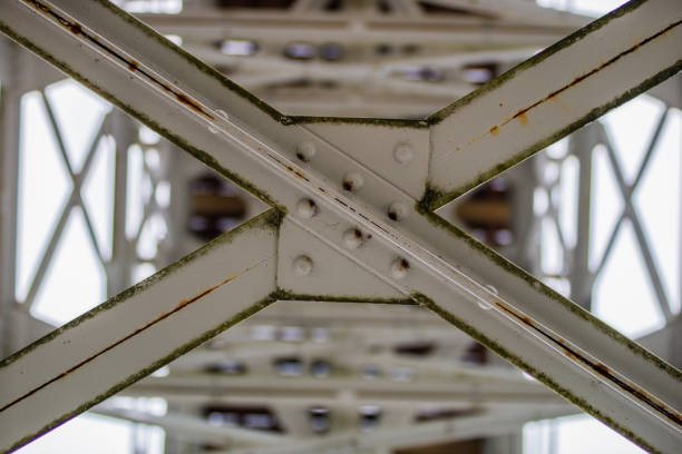 Steel construction, lattice connected by an old method for rivets. Truss in the old bridge connected by rivets on the river. Winter scenery.