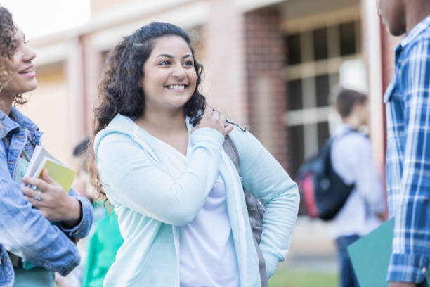 istock Teenage girl flirts with classmate between classes 904694802