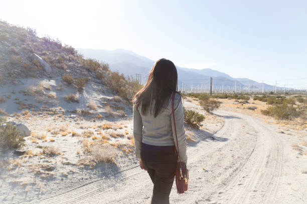istock Solitary Woman Walking a Dusty Road 904697340