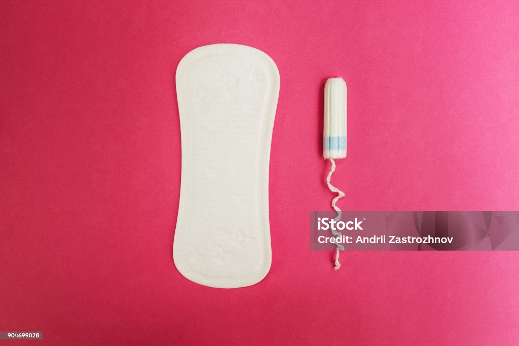 Female sanitary napkins and a tampon on a pink background. Sanitary pads and tampon on a pink background. Care Stock Photo