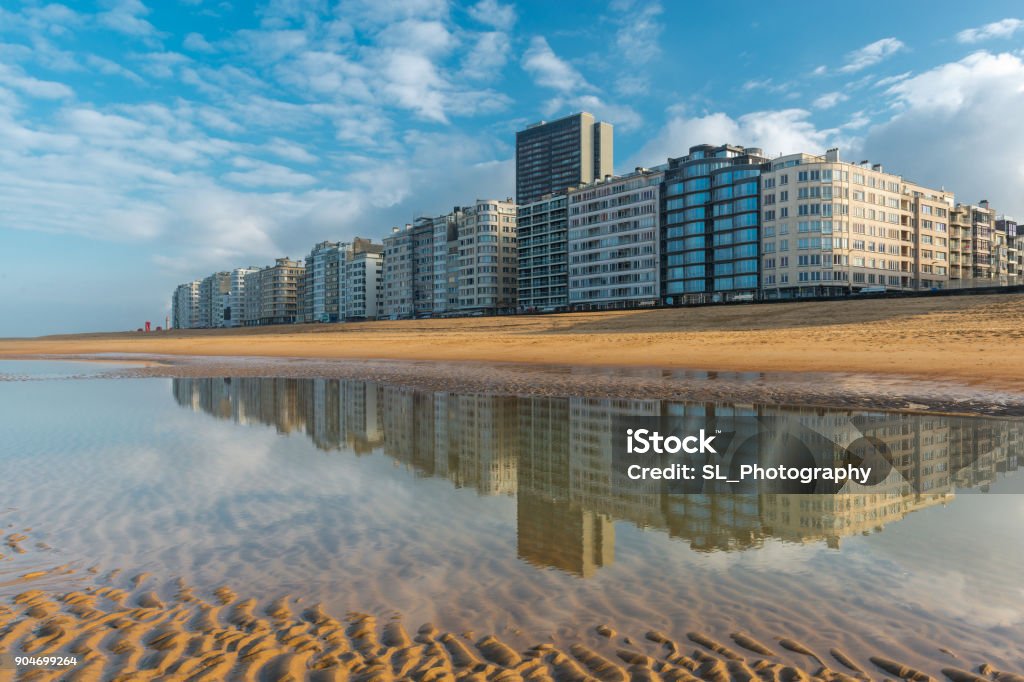 Ostend Skyline The skyline of Ostend City with its waterfront promenade reflecting in the North Sea with sand patterns at sunset, West Flanders, Belgium. Ostend Stock Photo