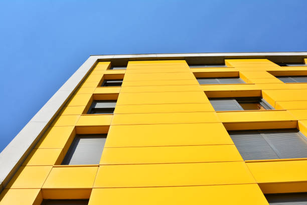 istock Yellow building with windows and blue sky 904701536