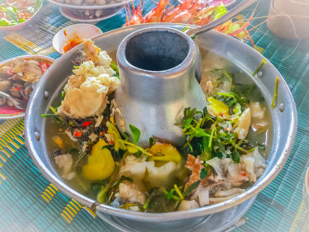 tom yum sleepy goby, marbled sleeper (oxyeleotris marmorata) fish in hot pot boiled with herb broth. tom yum or tom yam is a type of hot and sour thai soup with fragrant spices and herbs in the broth. - marmorata imagens e fotografias de stock