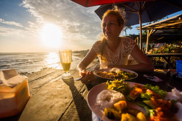 istock Young beautiful woman eating on restaurant terrace at sunset. 904717618