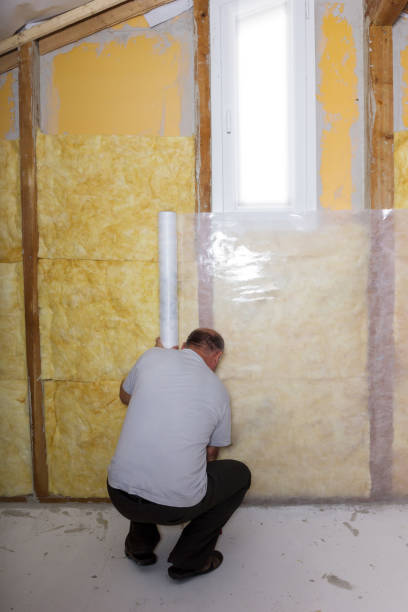 istock termal insulation at the attic room. Handyman installing white roll lean on wall 904718138