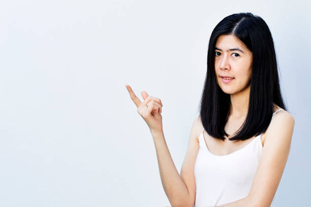 istock Young cute asian woman pointing 904726862