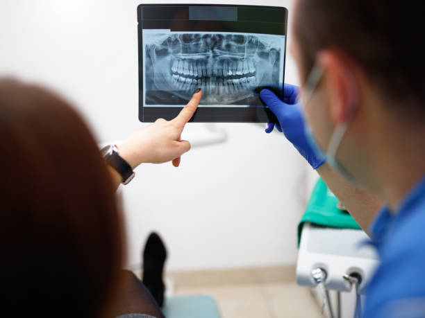 istock Dentist showing a patient her x-ray 904732480