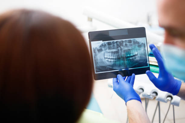 istock Dentist showing a patient her x-ray 904734568