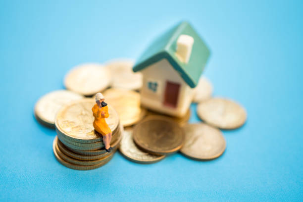 istock Woman sitting on stack coins and house 904770336