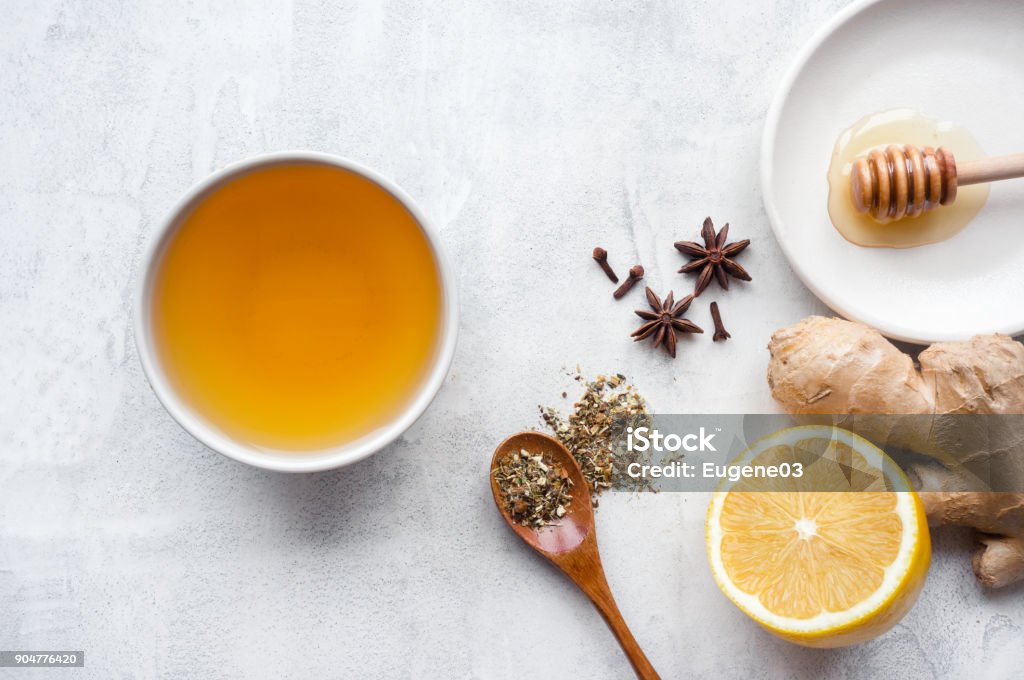 Hot herbal ginger tea. Green herbal tea with lemon and spices on concrete table. Top view. Tea - Hot Drink Stock Photo