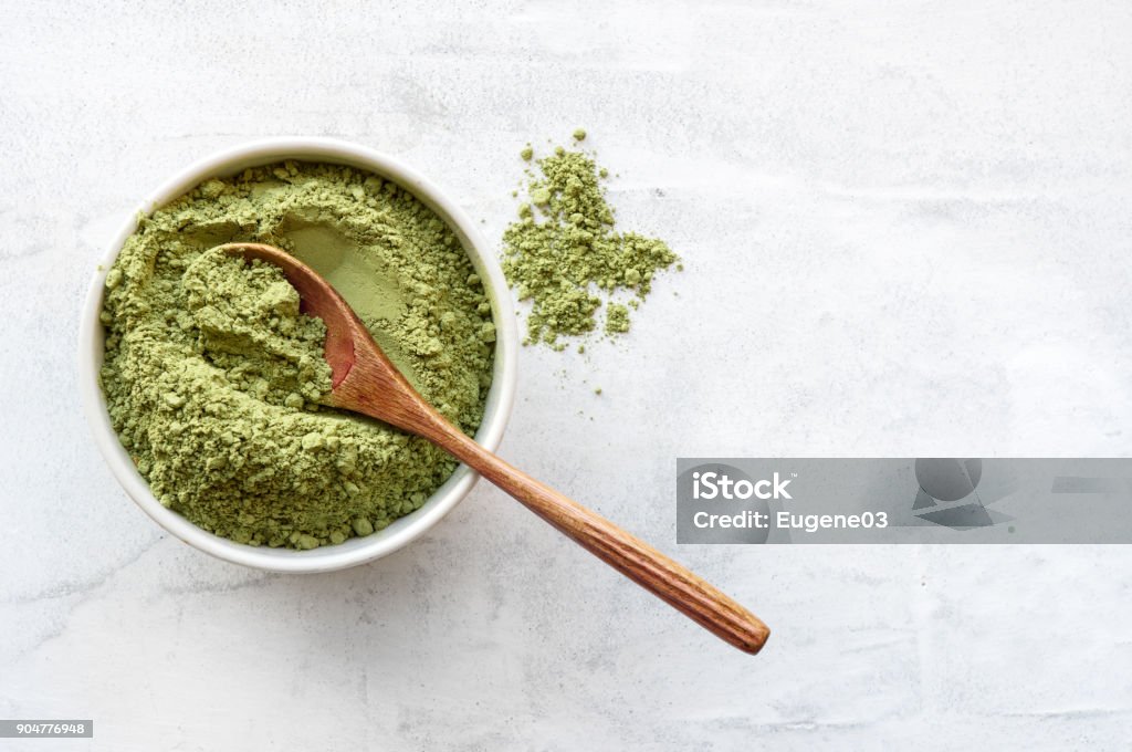 Green matcha tea powder. Top view. Matcha tea powder with spoon on white concrete background with copy space. Matcha Tea Stock Photo