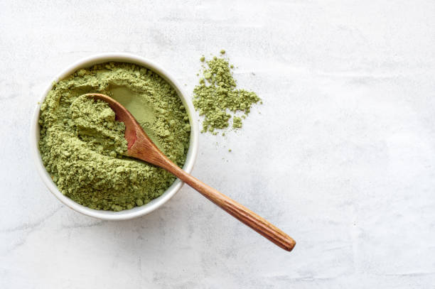 Green matcha tea powder. Top view. Matcha tea powder with spoon on white concrete background with copy space. matcha tea photos stock pictures, royalty-free photos & images