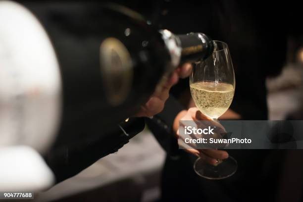 Waiter Pouring Champagne Into The Wine Glass In Restaurant Blurry Background Stock Photo - Download Image Now